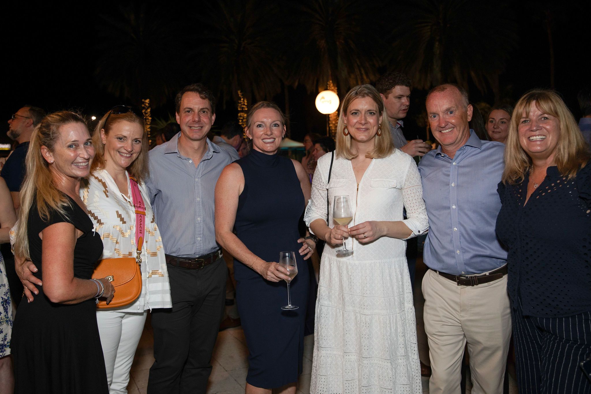 A group of seven people smile at the camera.